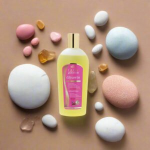 Zeenat Glow Booster Glycerin 16oz bottle surrounded by colorful bath stones on a beige background.